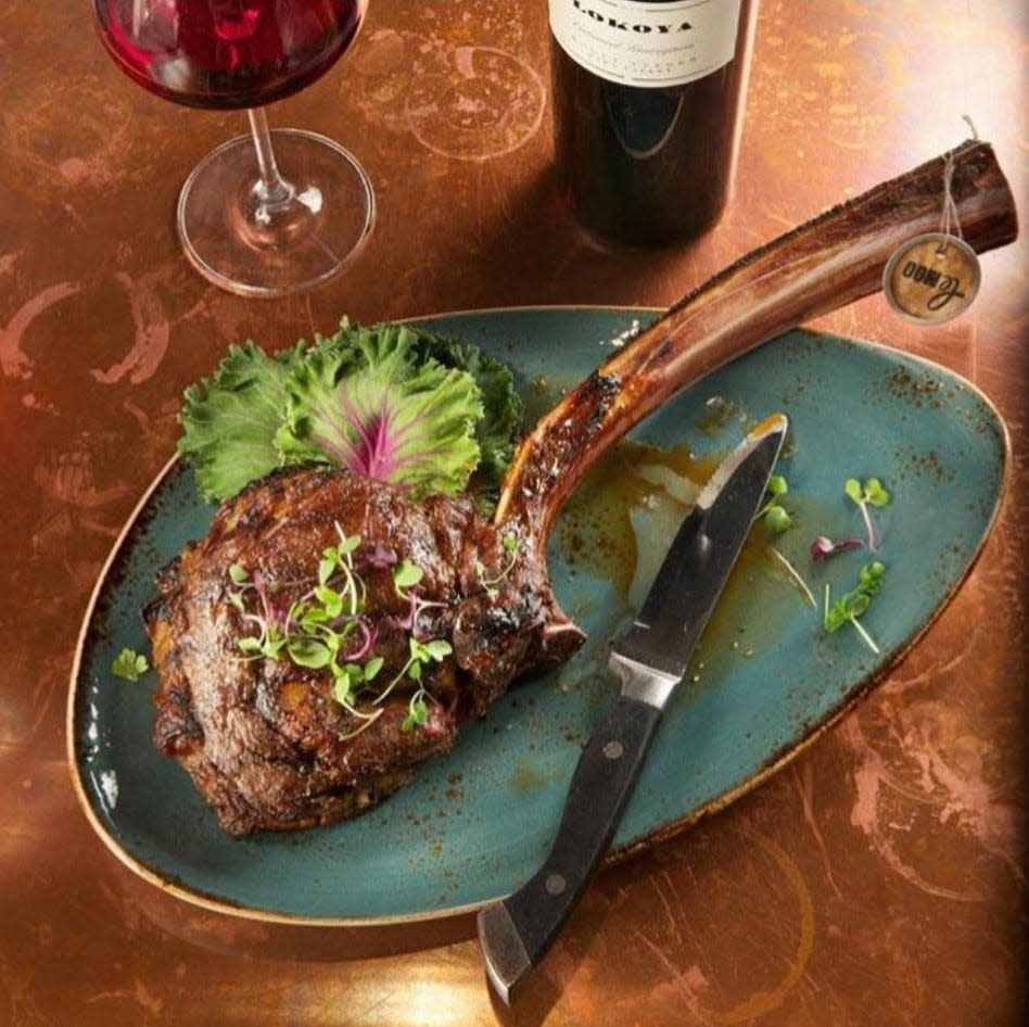 The Bone-in ribeye cowboy cut is a 32-ounce certified Angus beef tomahawk served at Le Moo restaurant in Louisville.