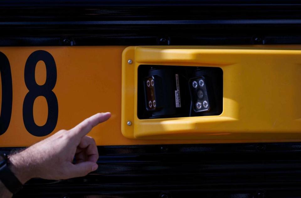 A Miami-Dade Public Schools official points to the new license plate reading cameras that are able to record up to eight lanes of traffic. The cameras are part of a new enforcement program to fine drivers who don’t stop for school buses. The program will start enforcing the fines on May 8. Alie Skowronski/askowronski@miamiherald.com