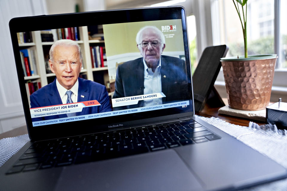 Former Vice President Joe Biden, presumptive Democratic presidential nominee, left, speaks as Senator Bernie Sanders, an Independent from Vermont, right, listens during a virtual event seen on an Apple Inc. laptop computer in Arlington, Virginia, U.S., on Monday, April 13, 2020. Sanders endorsed Biden during the joint livestream saying that Americans of all political affiliations should back the former vice president. Photographer: Andrew Harrer/Bloomberg