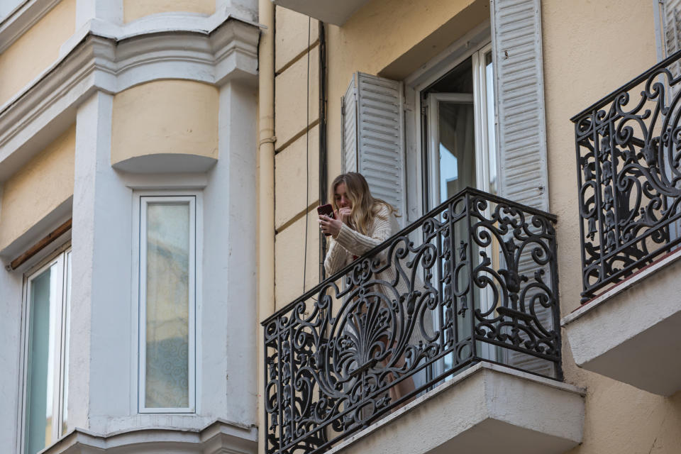 Una mujer consulta su teléfono móvil en el balcón de su casa de Madrid. (Foto: David Benito / Getty Images).
