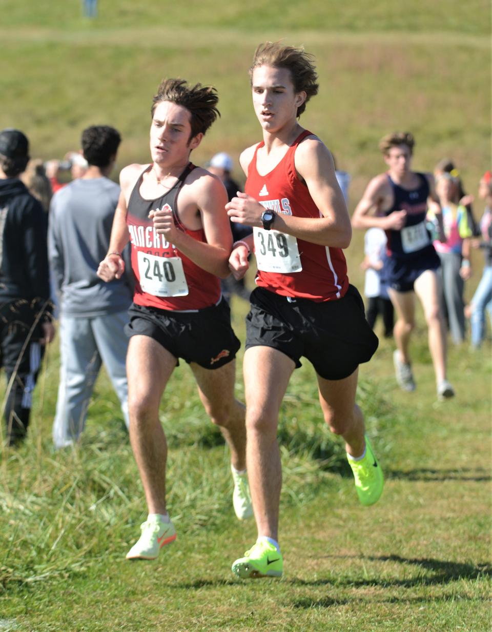 Minerva's Grasyn Rettig (black) runs alongside St. Clairsville's Ben Shields in the Division II district cross country meet on Saturday at Cambridge.