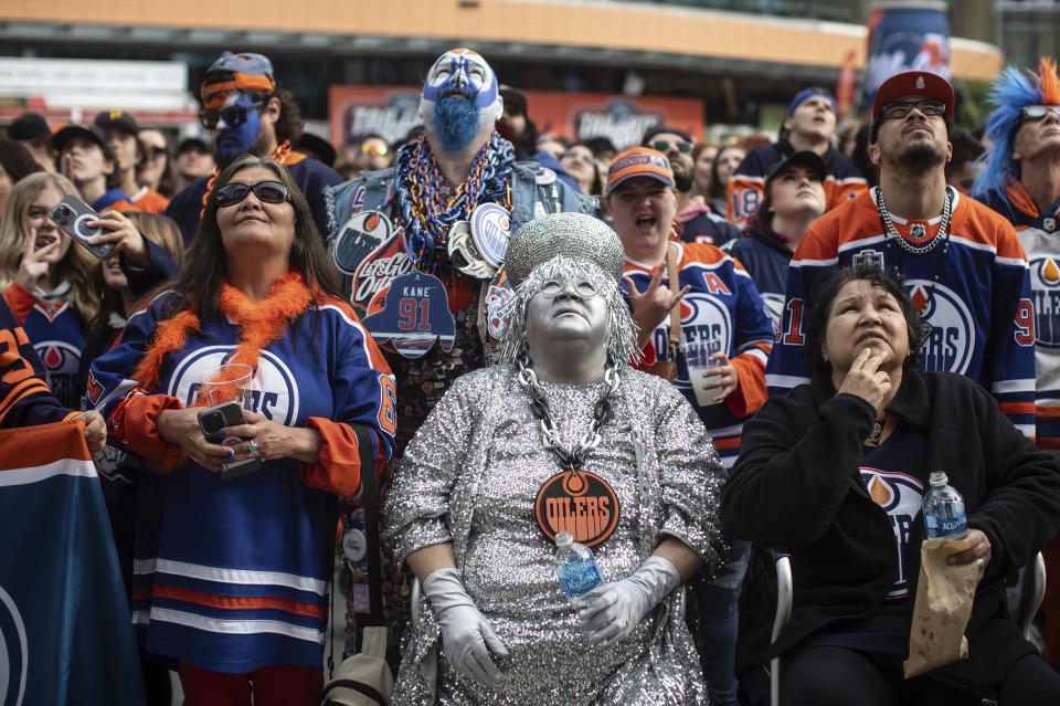 Edmonton Oilers fans watch coverage of Game 5 of the NHL hockey Stanley Cup Final between the Oilers and the Florida Panthers on a large screen Tuesday, June 18, 2024, in Edmonton, Alberta. (Jason Franson/The Canadian Press via AP)