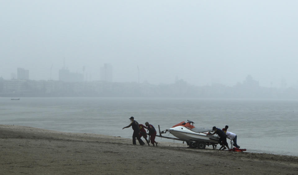 Rescue personnel relocate their jetski as part of precautions against cyclone on the Arabian Sea coast in Mumbai, India, Tuesday, June 2, 2020. Cyclone Nisarga in the Arabian Sea was barreling toward India's business capital Mumbai on Tuesday, threatening to deliver high winds and flooding to an area already struggling with the nation's highest number of coronavirus infections and deaths. (AP Photo/Rajanish Kakade)