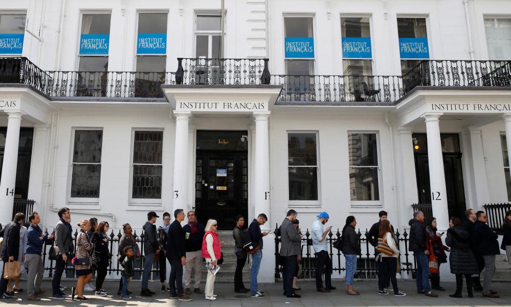 French expats queue along the street outside the Lycée Francais Charles de Gaulle to cast their vote.