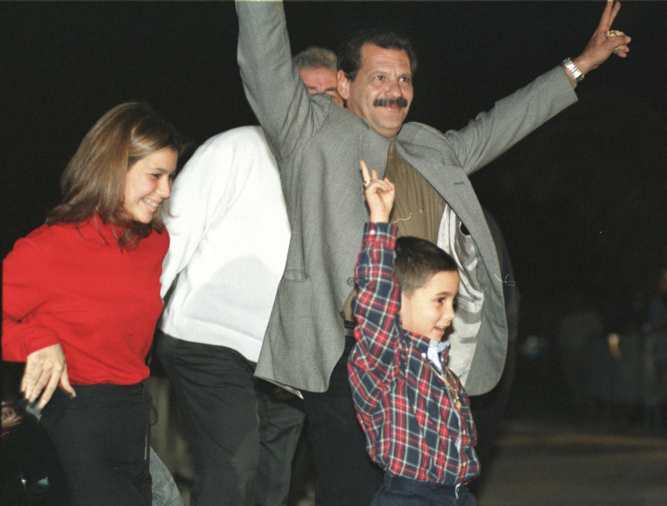 ARCHIVO - Elián González, abajo, su tío abuelo Lázaro González y su prima Marisleysis celebran con simpatizantes después de llegar a su casa en La Pequeña Habana de Miami, Florida, el 26 de enero de 2000, después de que Elián se reuniera con sus abuelas que habían venido en avión desde Cuba. (AP Foto/Alan Diaz, Archivo)