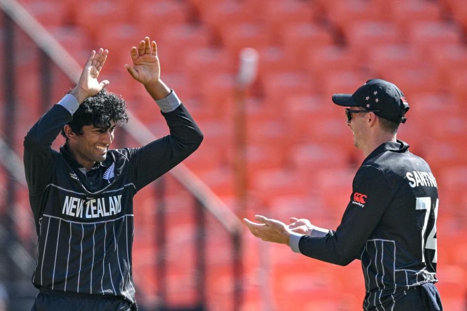 Rachin Ravindra celebrates with his teammate after taking the wicket of England’s Harry Brook during the 2023 ICC men’s cricket World Cup one-day international (ODI) match between England and New Zealand (AFP via Getty Images)