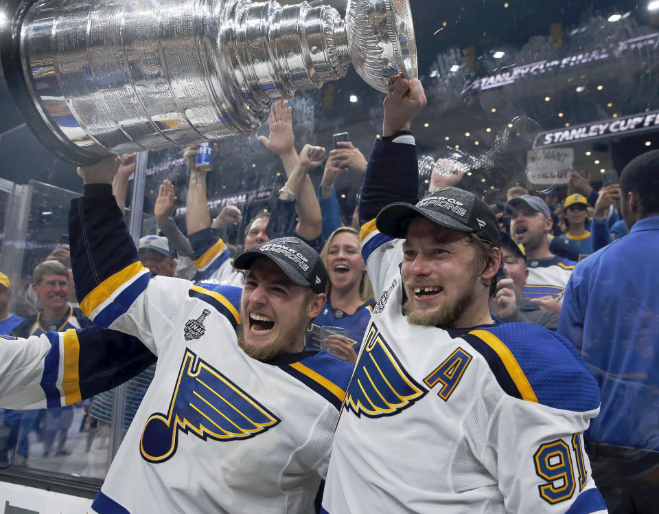 St. Louis Blues' Ivan Barbashev, left, and Vladimir Tarasenko, both of Russia, hold the Stanley Cup as fans in the stands celebrate after the Blues defeated the Boston Bruins in Game 7 of the NHL Stanley Cup Final, Wednesday, June 12, 2019, in Boston. (AP Photo/Michael Dwyer)