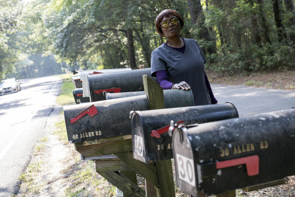 Queen Davis stands next to several mailboxes that that belong to family members on Allen Road, Tuesday, July 18, 2023, in Hilton Head Island, S.C. The road was named after a family member and former slave purchase the land in 1896. (AP Photo/Stephen B. Morton)