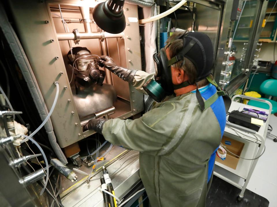 A technician in a gas mask takes a reading from a dummy in Dugway Proving Ground in 2017.