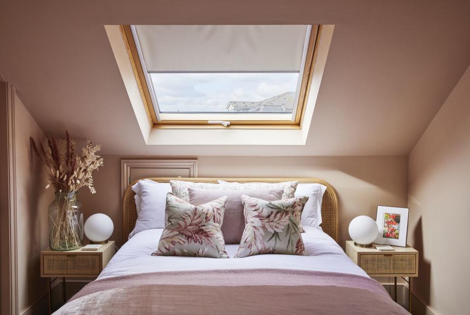 velux window and bed with pink bedlinen in loft room