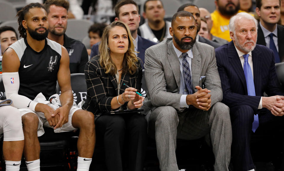 Hammon and Spurs guard Patty Mills on the bench next to head coach Gregg Popovich, right, and assistant coach Ime Udoka, now the head coach of the Houston Rockets.<span class="copyright">Edward A. Ornelas—Getty Images</span>