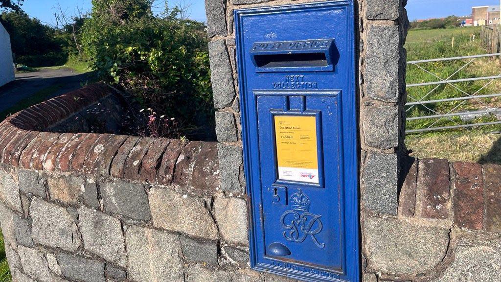 A blue Guernsey post box