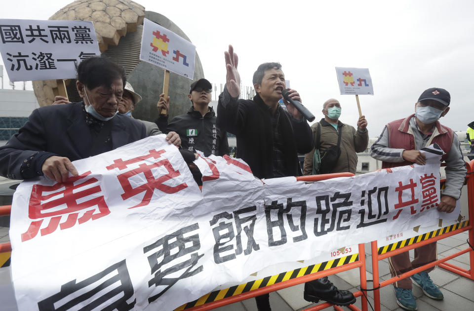 Protesters shout slogans as former Taiwan President Ma Ying-jeou leaves for China outside of Taoyuan International Airport in Taoyuan City, Northern Taiwan, Monday, March 27, 2023. Ma is scheduled to visit China Monday on a 12-day tour, a day after Taiwan lost another one of its diplomatic allies to China. Banner reads "Ma is a beggar and kneels to meet the Communists." (AP Photo/Chiang Ying-ying)