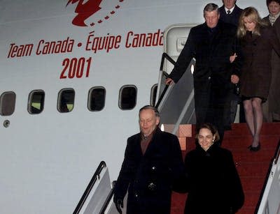 In February 2001, Jean Chrétien and his wife Aline, followed by Ontario Premier Mike Harris, arrive in Beijing for the start of the Team Canada Trade mission. (CP PHOTO/Fred Chartrand)