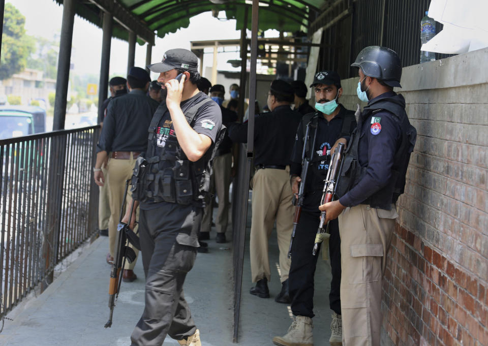 FILE - Police officers gather at an entry gate of district court following the killing of Tahir Shamim Ahmad, who was in court accused of insulting Islam, in Peshawar, Pakistan, Wednesday, July 29, 2020. Tahir Shamim Ahmad was a U.S. citizen, according to a U.S. State Department statement. (AP Photo/Muhammad Sajjad)