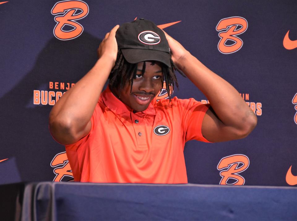Benjamin's Chauncey Bowens puts on his University of Georgia hat as he signs his letter of intent on Dec. 20, 2023.
