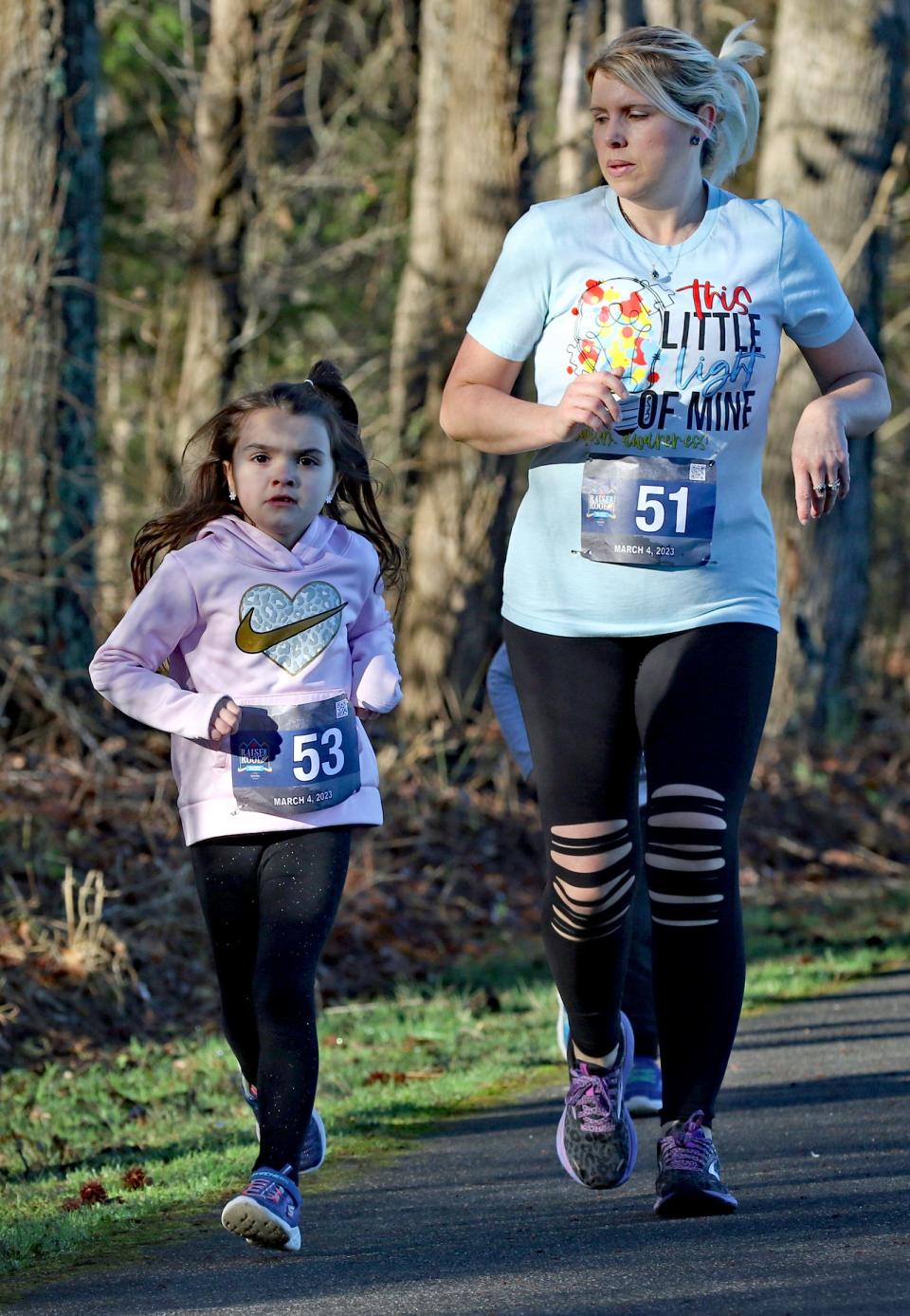 Amber Lange runs along side one of her daughters, 6-year-old Alexa Lange, during the Raise the Roof 5K early Saturday morning, March 4, 2023, at Rankin Lake Park.