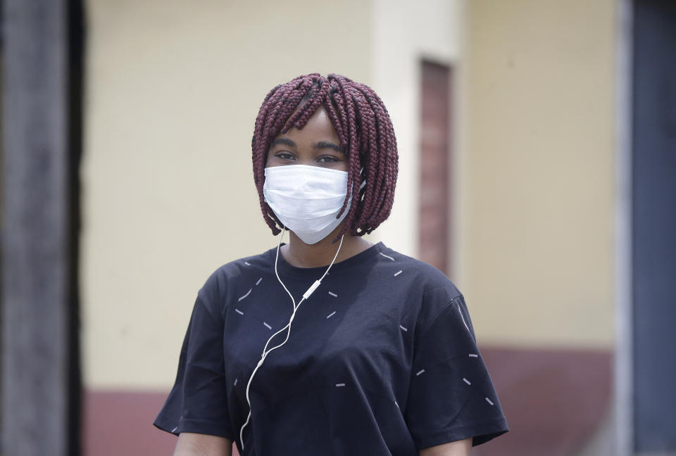 A woman wearing a face mask walks at the Yaba Mainland hospital where an Italian citizen who entered Nigeria on Tuesday from Milan on a business trip, the first case of the COVID-19 virus is being treated in Lagos Nigeria Friday, Feb. 28, 2020. Nigeria's health authorities have reported the country's first case of a new coronavirus in Lagos, the first confirmed appearance of the disease in sub-Saharan Africa. (AP Photo/ Sunday Alamba)