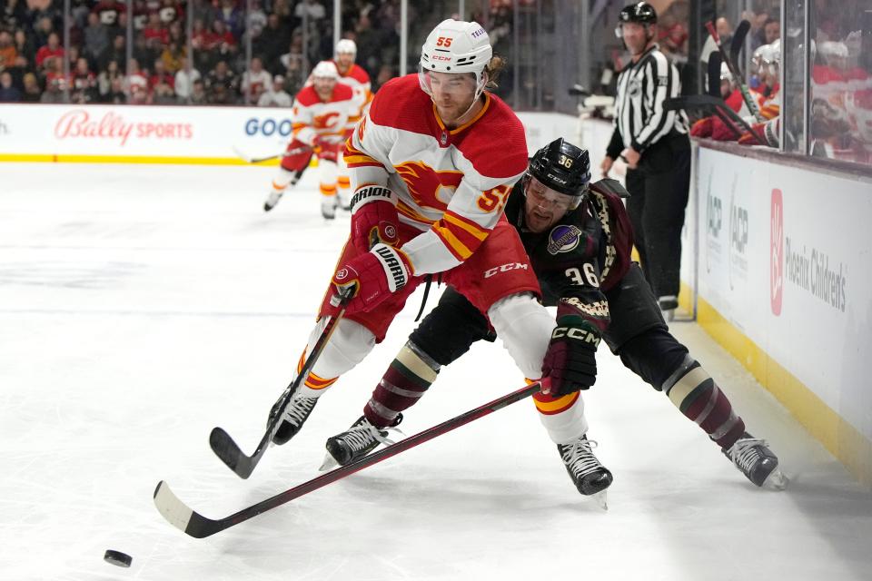 Arizona Coyotes right wing Christian Fischer (36) pressures Calgary Flames defenseman Noah Hanifin in the first period during an NHL hockey game, Wednesday, Feb. 22, 2023, in Tempe, Ariz. (AP Photo/Rick Scuteri)