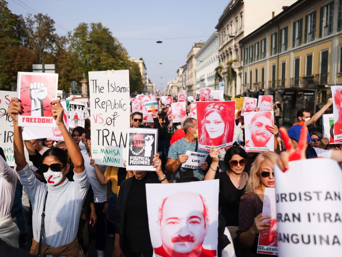 People take to the streets to protest over the death of a young woman in police custody in Iran, during a demonstration in Milan, Italy on Oct. 16. Demonstrators protested the death of Mahsa Amini, a 22-year-old woman who had been detained by Iran's morality police in the capital of Tehran for allegedly not adhering to Iran's strict Islamic dress code. (Alessandro Bremec/LaPresse via The Associated Press - image credit)