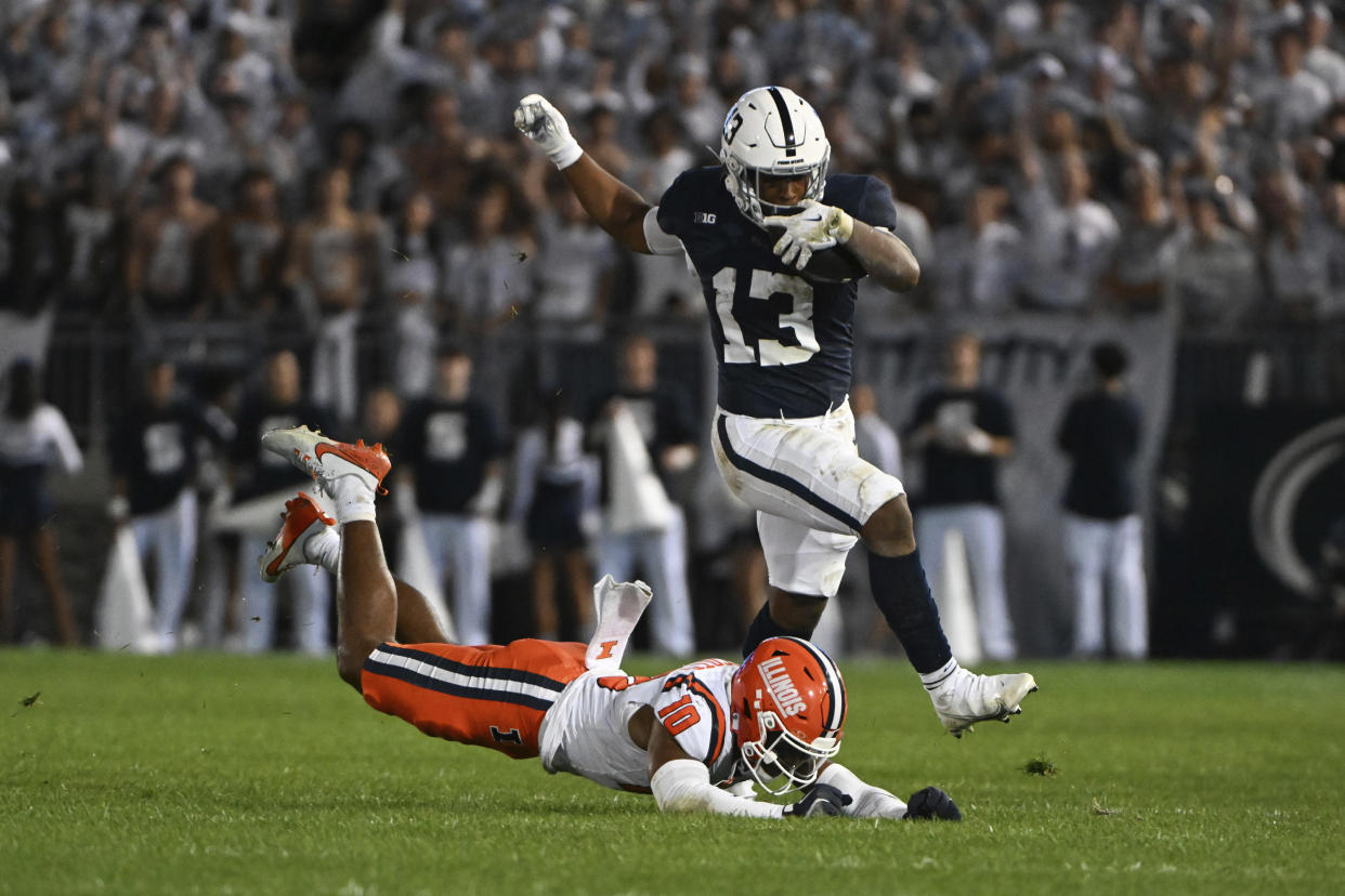 Penn State running back Kaytron Allen (13) runs past Illinois defensive back Miles Scott (10) during the second quarter of an NCAA college football game, Saturday, Sept. 28, 2024, in State College, Pa. (AP Photo/Barry Reeger)