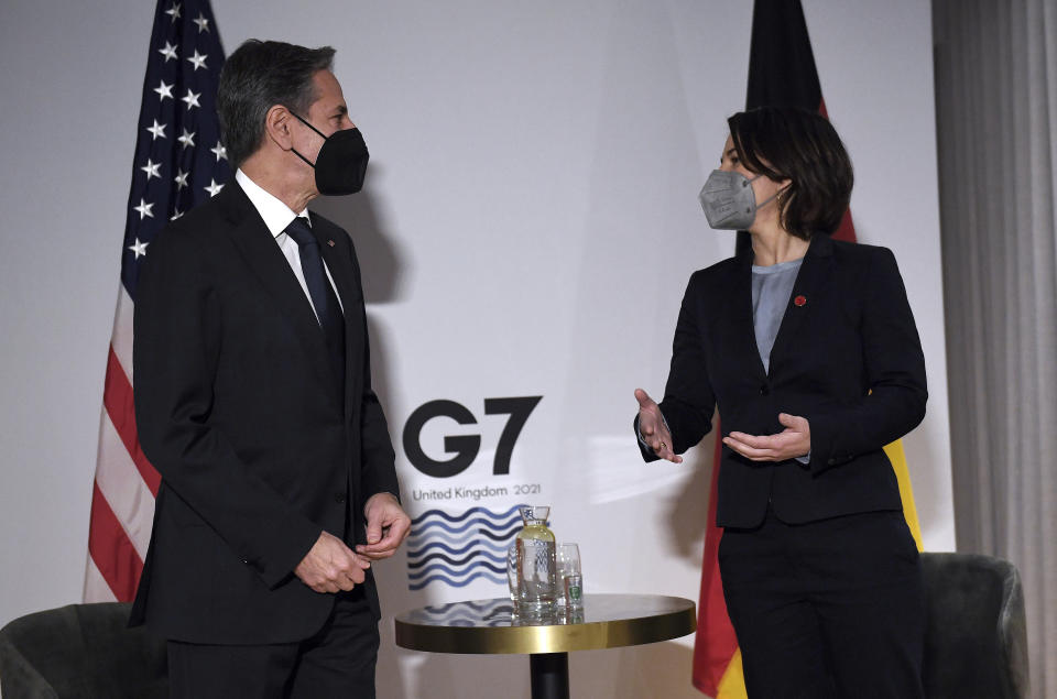 US Secretary of State Antony Blinken, left, and Germany's Foreign Minister Annalena Baerbock, wearing face coverings to combat the spread of the coronavirus, speak before a bilateral meeting ahead of the G7 foreign ministers summit in Liverpool, England, Friday, Dec. 10, 2021. Blinken arrived in Britain for a G7 ministers' meeting before visiting Indonesia, Malaysia and Thailand. (Olivier Douliery/Pool Photo via AP)