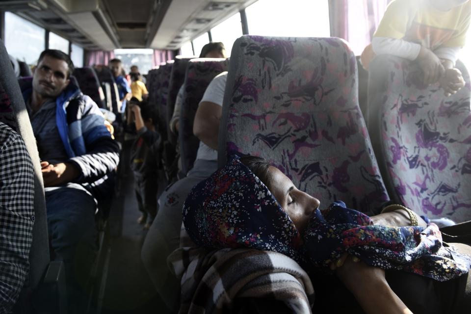 A woman sleeps inside a bus at the toll stations of Malgara, near the Greek port city of Thessaloniki, on Wednesday, Oct. 23, 2019. Protesting local residents in northern Greece set up roadblocks to try and prevent migrants from settling in the area. The government has promised to expand a network of refugee camps and hotel residence programs on the Greek mainland in an effort to ease severe overcrowding at facilities on islands near the Turkish coast. (AP Photo/Giannis Papanikos)