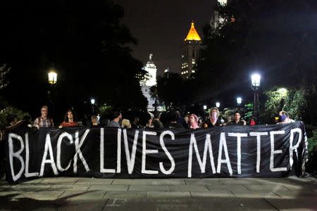 People hold up a banner during a Black Lives Matter protest outside City Hall in Manhattan, New York, U.S., August 1, 2016. REUTERS/Andrew Kelly