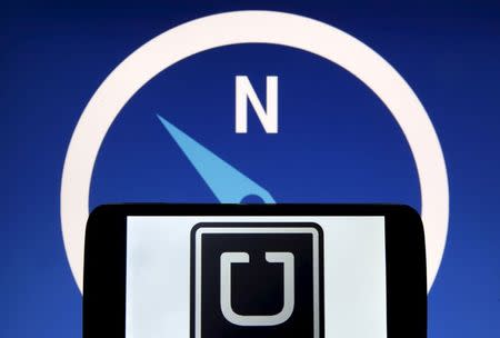 Uber logo is seen on a smartphone in front of a displayed logo of HERE, Nokia Oyj's map business, in Zenica, Bosnia and Herzegovina, in this May 8, 2015 photo illustration. REUTERS/Dado Ruvic