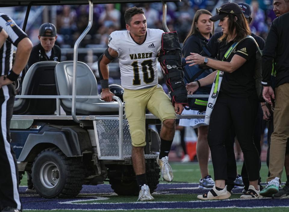 Warren Central's Keith Jackson (10) climbs onto a golf cart after an injury on the field Friday, Sept. 15, 2023, during the game against the Ben Davis Giants at Ben Davis High School in Indianapolis. The Ben Davis Giants defeated Warren Central, 31-28.