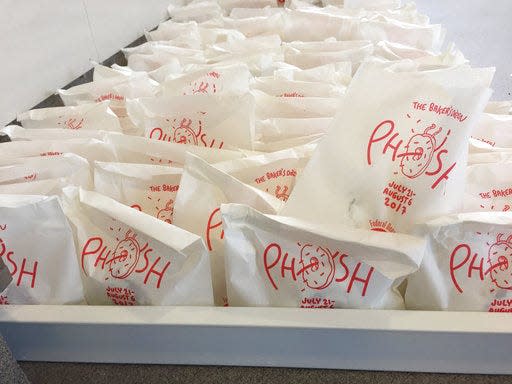 In this July 26, 2017 photo, bags of doughnuts are prepared to be handed out to fans of the band Phish in New York. The band is handing doughnuts out at its "Baker's Dozen" residency at New York's Madison Square Garden. (AP Photo/Josh Cornfield)