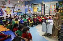 Students wearing protective masks attend a lecture as part of a coronavirus awareness campaign at a school in Kolkata.