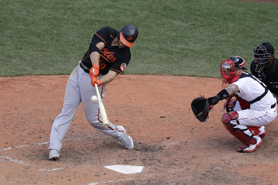 Baltimore Orioles' Chris Davis, left, hits an RBI-double as Boston Red Sox's Christian Vazquez looks on during the ninth inning of a baseball game, Sunday, July 26, 2020, in Boston. (AP Photo/Steven Senne)