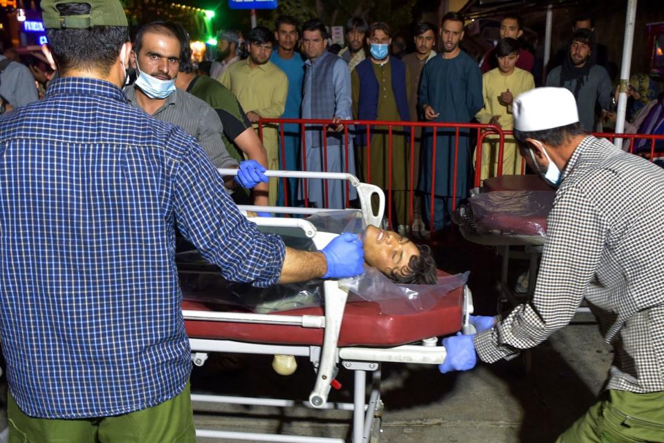 Volunteers and medical staff bring an injured man on a stretcher to a hospital