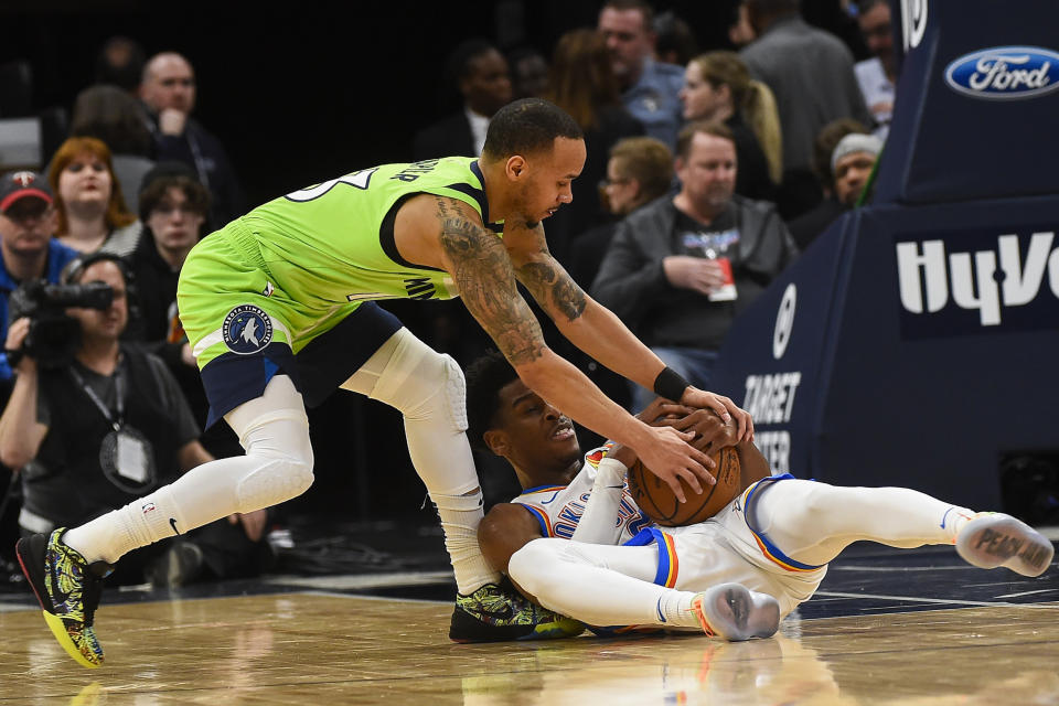 Minnesota Timberwolves guard Shabazz Napier, left, and Oklahoma City Thunder guard Shai Gilgeous-Alexander fight for a loose ball resulting in a jump ball during the first half of an NBA basketball game Saturday, Jan. 25, 2020, in Minneapolis. (AP Photo/Craig Lassig)