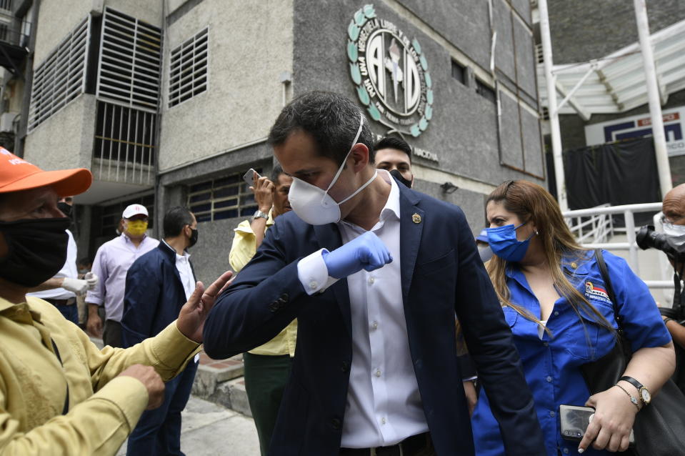 FILE - In this June 17, 2020 file photo, Venezuelan opposition leader Juan Guiado greets a supporter after a visit to the headquarters of Democratic Action political party in Caracas, Venezuela, the day after Venezuela's Supreme Court ordered its takeover ahead of parliamentary elections expected this year. More than a year after the U.S.-backed politician rose up to oust Venezuelan President Nicolás Maduro, the socialist leader holds a yet stronger grip on power, thanks partly to the novel coronavirus. (AP Photo/Matias Delacroix, File)