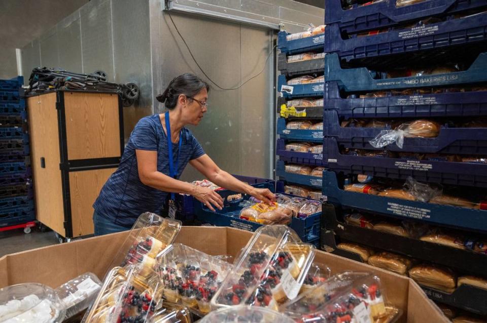 Volunteer Lillian Zimmerle arranges bread and desserts at Elk Grove Food Bank Services on Wednesday, July 24, 2024. Zimmerle has voluntered for five years and said many of the desserts are surplus product from Costco.
