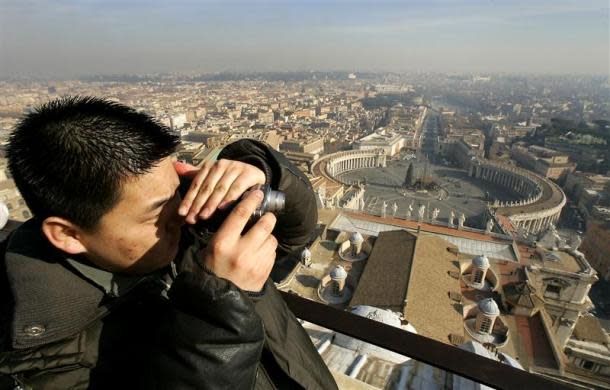 A tourist takes a photograph from the balcony overlooking Saint Peter's square at the Vatican January 18, 2005.