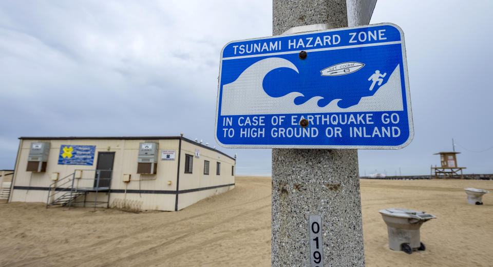 A tsunami hazard sign reads: Tsunami hazard zone. In case of earthquake go to high ground or inland.