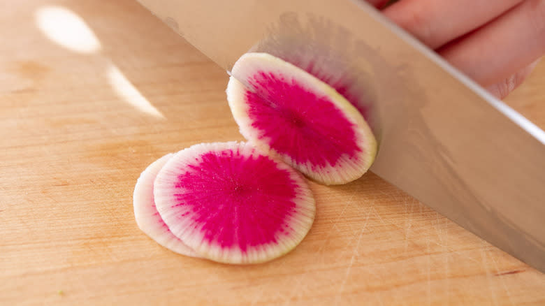 hand chopping watermelon radish