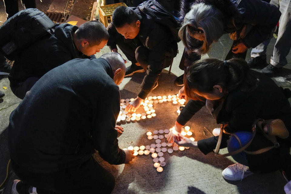 Pro-democracy supporters light candles outside the Chinese Consulate in Sydney, Australia, Saturday, June 4, 2022. Saturday marks the anniversary of China's bloody 1989 crackdown on pro-democracy protests at Beijing's Tiananmen Square. (AP Photo/Mark Baker)