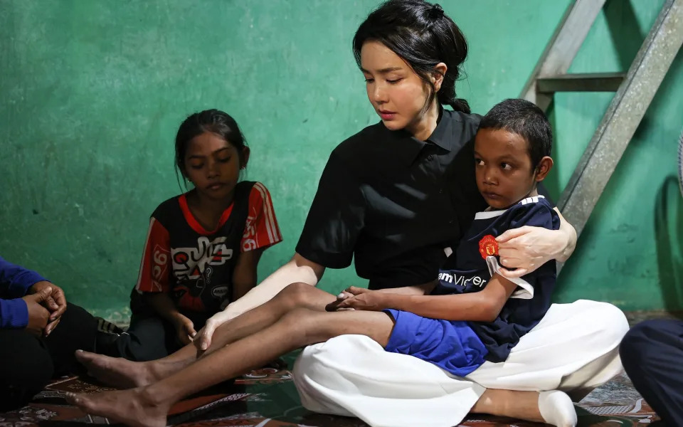 Kim Keon-hee holds a gaunt young boy with a heart condition at his family home in Phnom Penh, Cambodia - Office of the President of South Korea