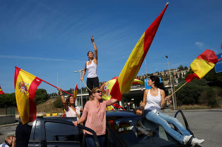 People wave Spanish flags as they gather at port to try to give supplies to Spanish National Police and Guardia Civil officers, who are housing in ferry boats, in Barcelona, Spain, September 24, 2017. REUTERS/Albert Gea