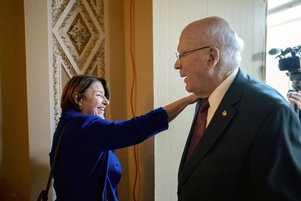 Sen. Amy Klobuchar, D-Minn., chair of the Senate Rules Committee, left, greets Sen. Patrick Leahy, D-Vt., the president pro temper of the Senate, as he walks to his office at the Capitol in Washington, Monday, Dec. 19, 2022. The U.S. Senate's longest-serving Democrat, Leahy is getting ready to step down after almost 48 years representing his state in the U.S. Senate. (AP Photo/J. Scott Applewhite)