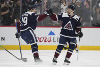 Colorado Avalanche center Nathan MacKinnon (29) celebrates with a teammate after scoring a goal against the Minnesota Wild in the first period of an NHL hockey game Tuesday, April 9, 2024, in Denver. (AP Photo/Bart Young)