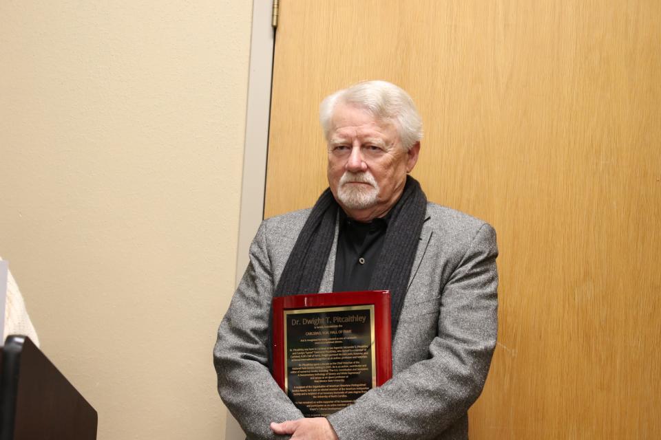 Dr. Dwight T. Pitcaithley stands with a plaque honoring his induction into the Carlsbad Hall of Fame on Jan. 28, 2023.