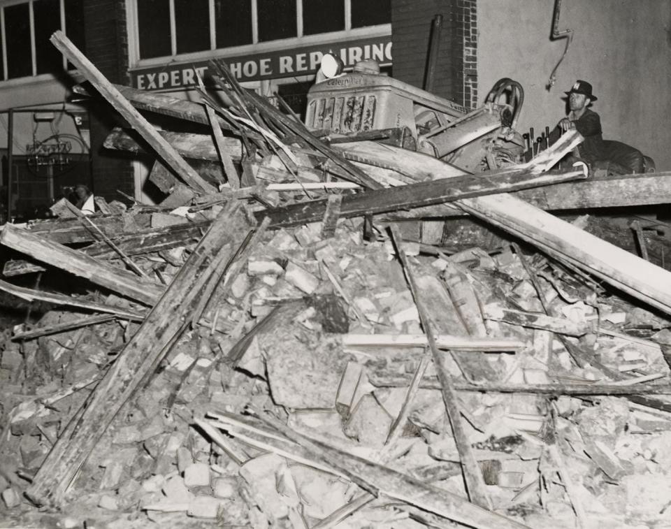 A bulldozer pushes debris along Pryor's main street, clearing the sidewalks after a violent tornado had destroyed parts of the town the afternoon of April 27, 1942.