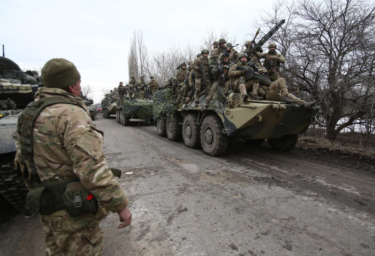 Ukrainian servicemen, on tanks, prepare to repel an attack.