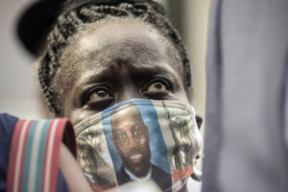 Ahmaud Arbery's aunt, Kim Arbery, listens to family attorney S. Lee Merritt speak with reporters in front of the Glynn County Courthouse after the preliminary hearing of Travis McMichael, Gregory McMichael and William Bryan, Thursday, June 4, 2020, in Brunswick, Ga. The three men are accused of shooting her nephew while he ran through their neighborhood in February. (AP Photo/Stephen B. Morton)