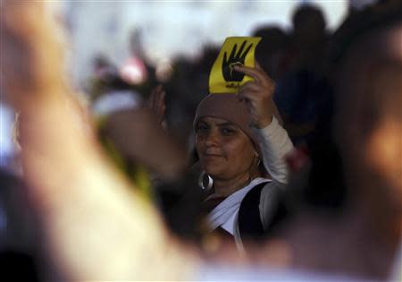 A supporter of ousted Egyptian President Mohamed Mursi holds up a label showing the "Rabaa" or "four" gesture, in reference to the police clearing of Rabaa al-Adawiya protest camp on August 14, during a protest against the military and interior ministry in the southern suburb of Maadi, September 3, 2013. REUTERS/Amr Abdallah Dalsh